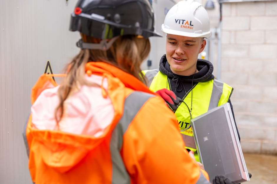 Two women in orange vests talking to each other