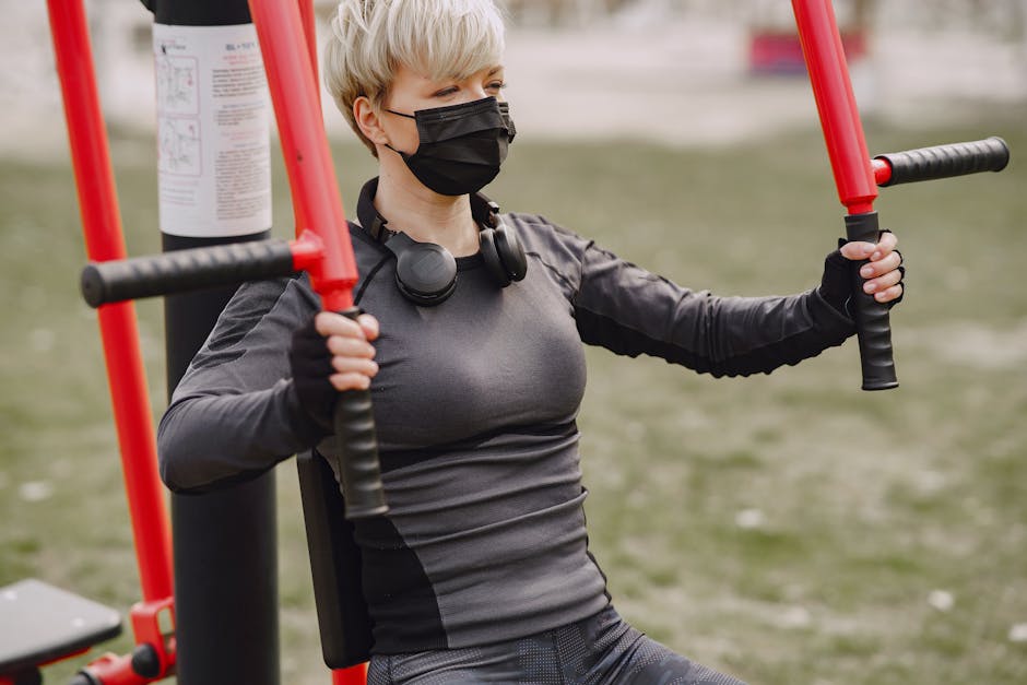 Determined sportswoman in mask working out on street sport equipment