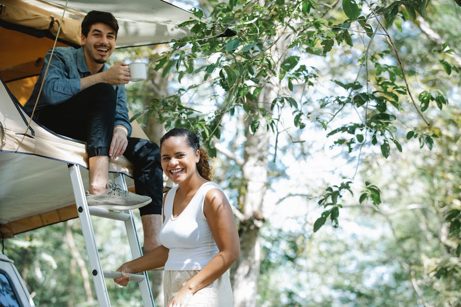 Loving young diverse couple having fun in tent during camping trip in nature