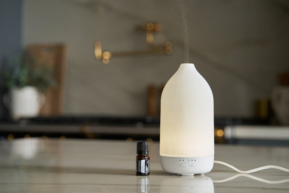 A Bottle of Essential Oil and Essential Oil Diffuser Standing in a Kitchen