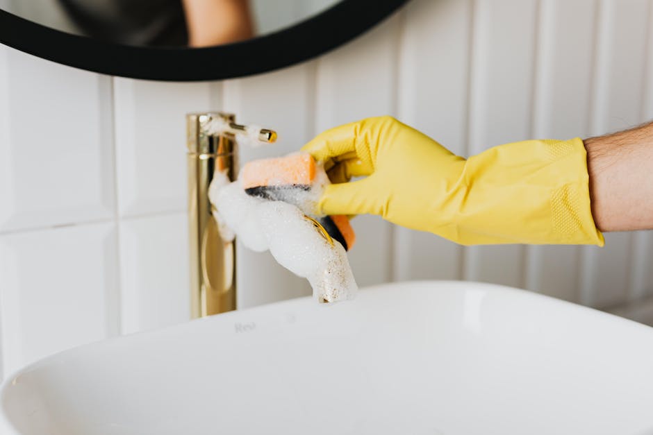 Crop man washing faucet in bathroom