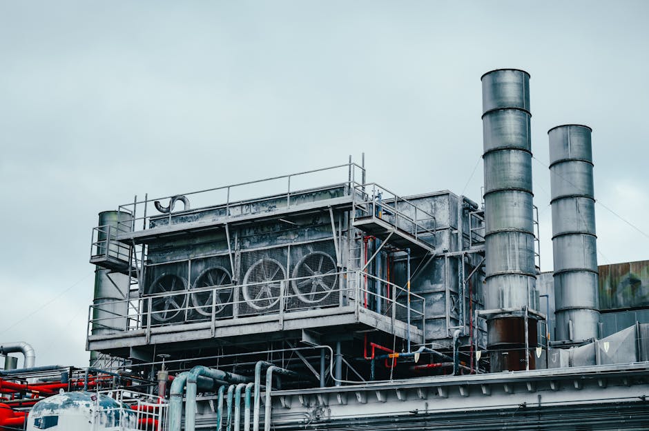 Exterior view of large industrial construction with metal tubes located on factory in daytime on cloudy weather