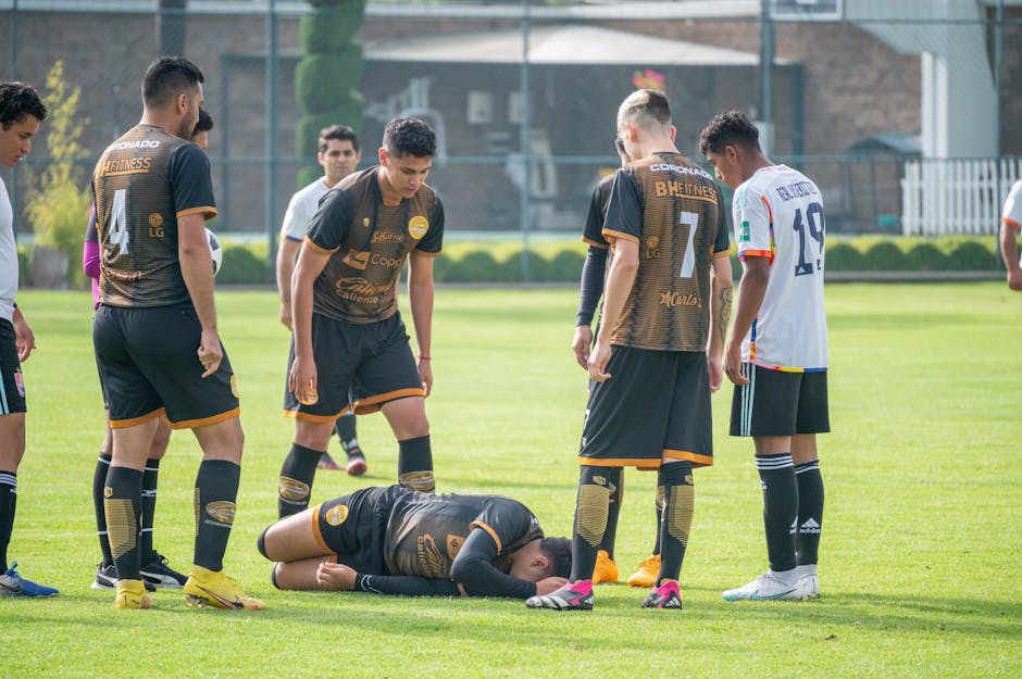 A soccer player is on the ground after a game