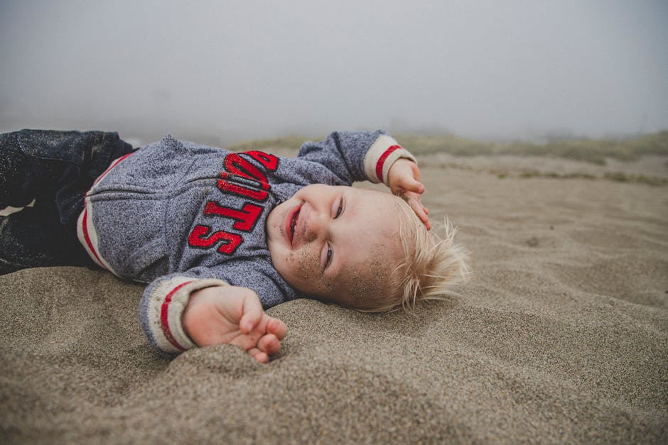 Photo of Boy Lying on Sand