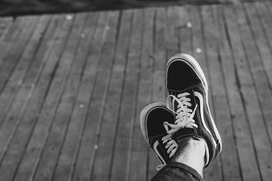 Monochrome Photo of a Person’s Shoes