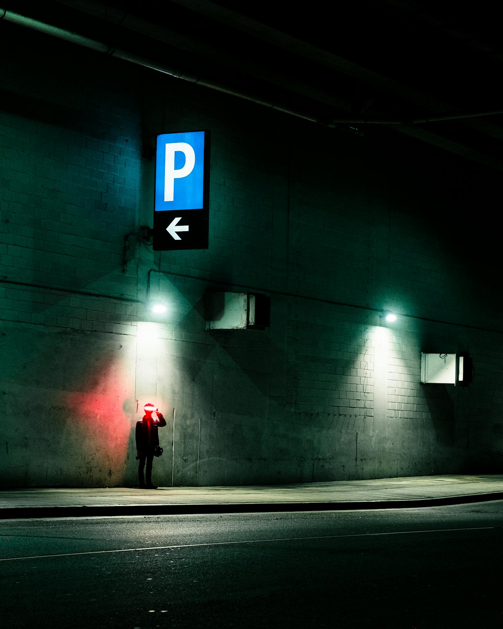 Person Standing under a Parking Sign