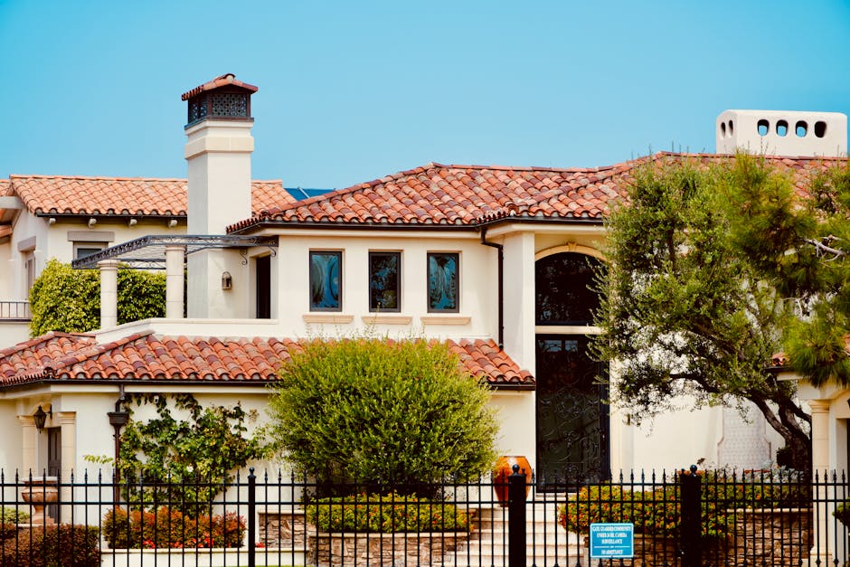 A large house with a black fence and a white roof