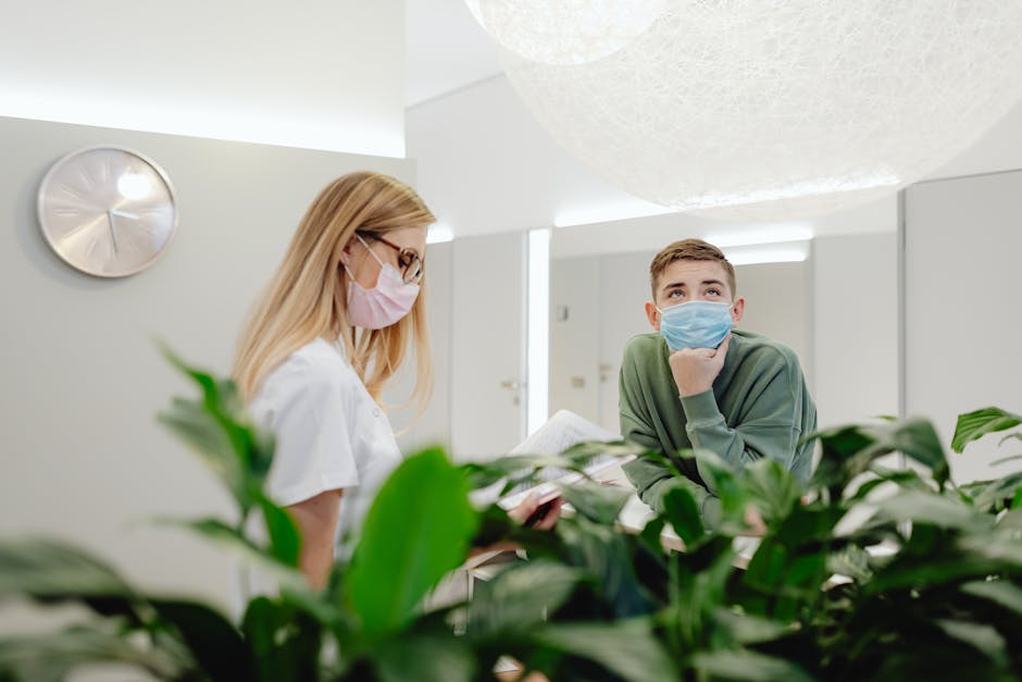 Young Man and Woman Standing Next to a Reception Desk in a Clinic