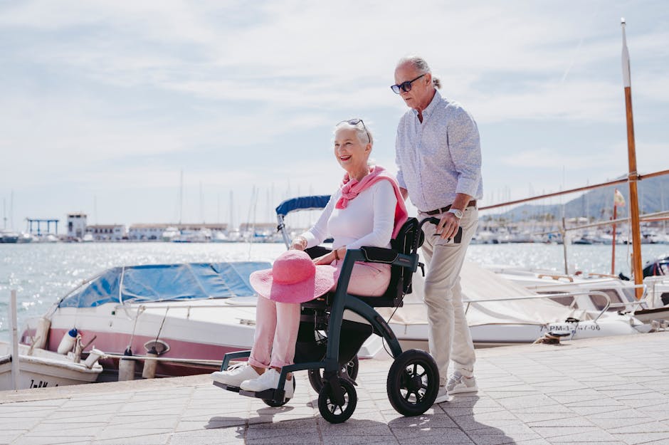 A man and woman in a wheelchair near a marina