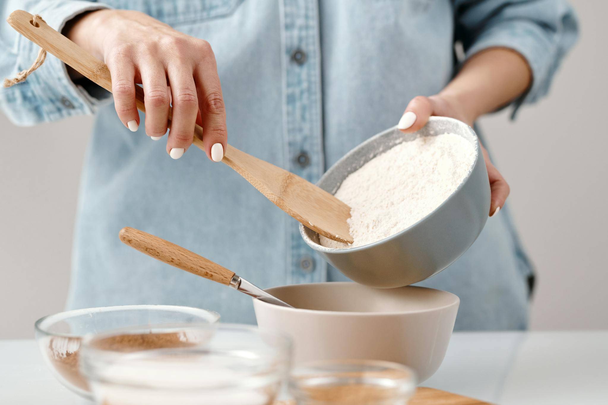 Crop baker scattering powdered flour on table