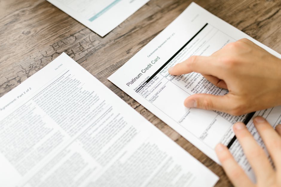 Person Holding White Printer Paper on Wooden Surface