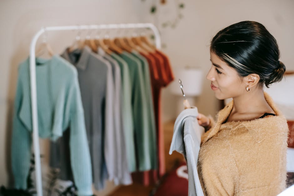 Unrecognizable ethnic female selecting clothes in room