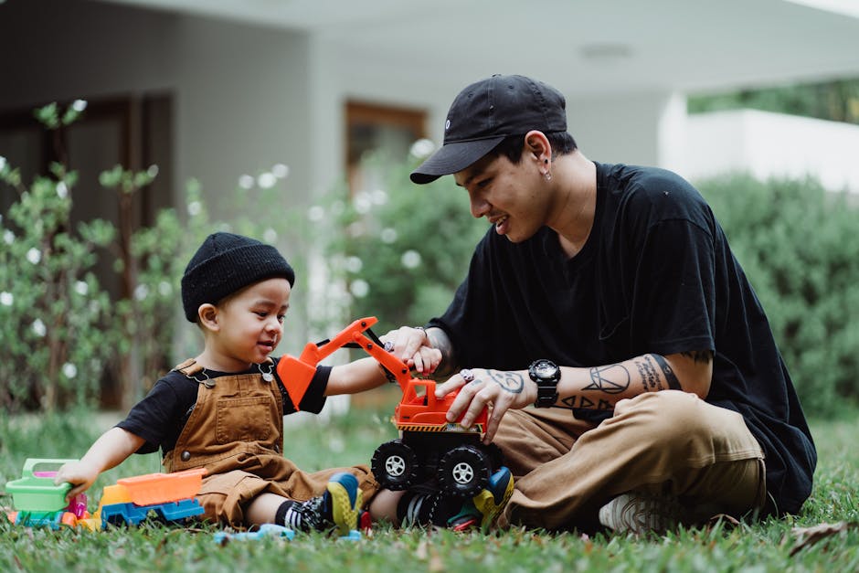 Padre e hijo jugando con coches de juguete al aire libre