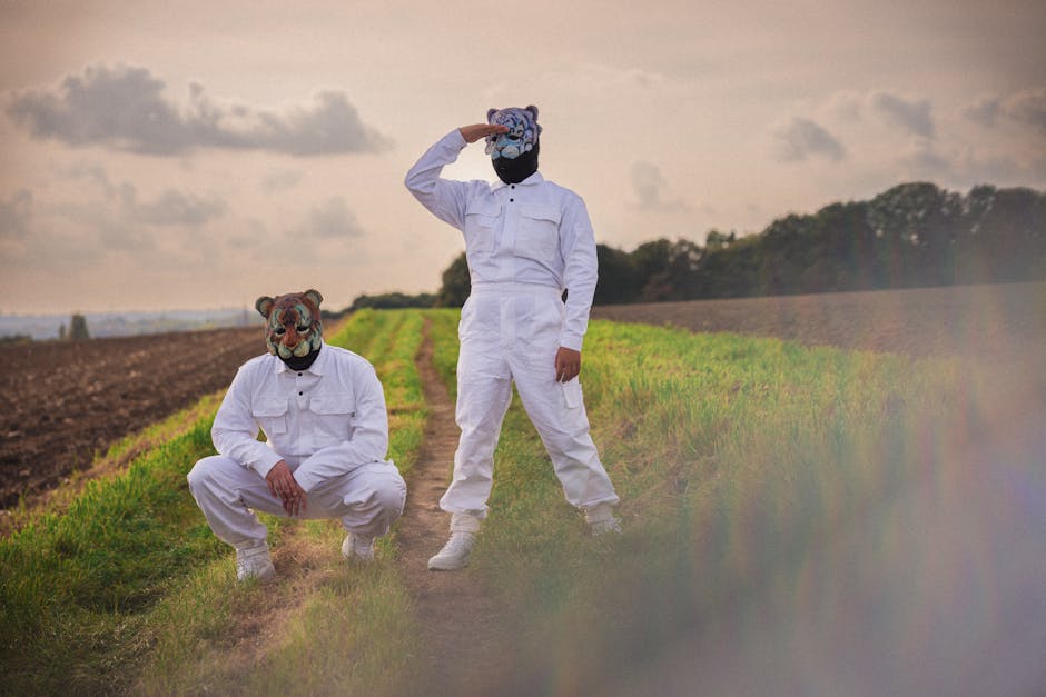 Two people in white suits and masks standing in a field