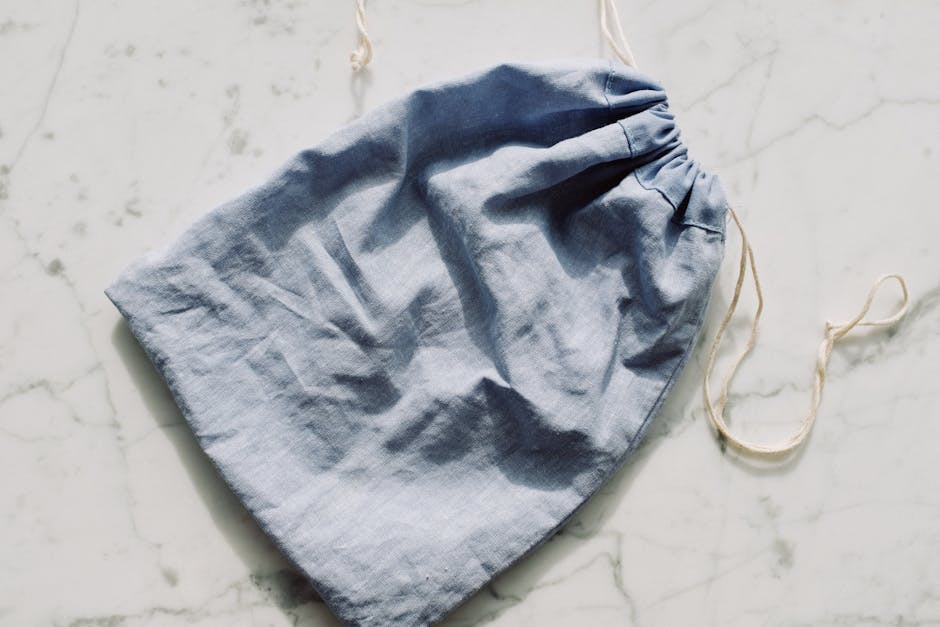 Empty textile blue bag with drawstrings placed on table in light room