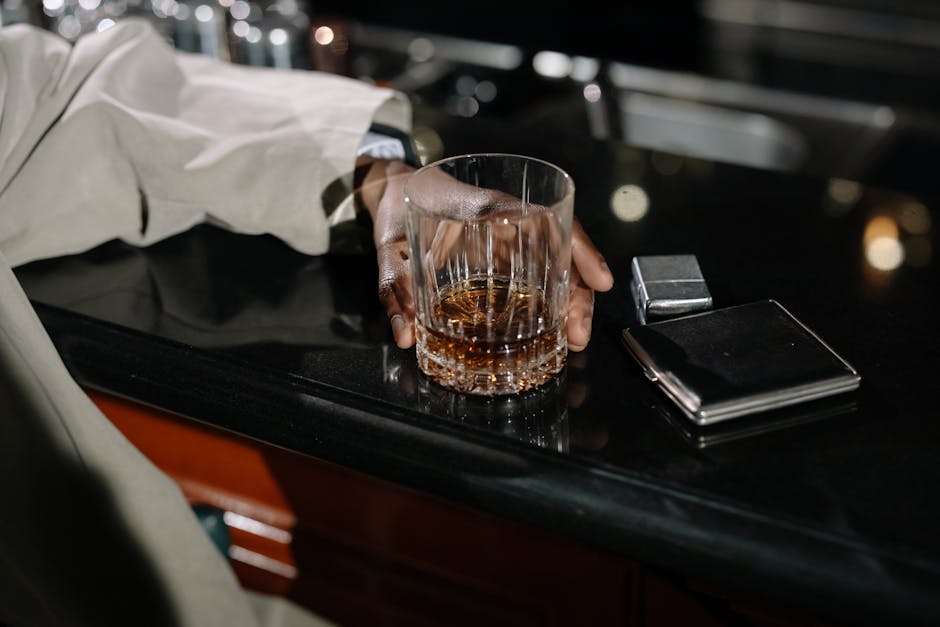 Close-Up Photo of Person Holding Glass of Whiskey