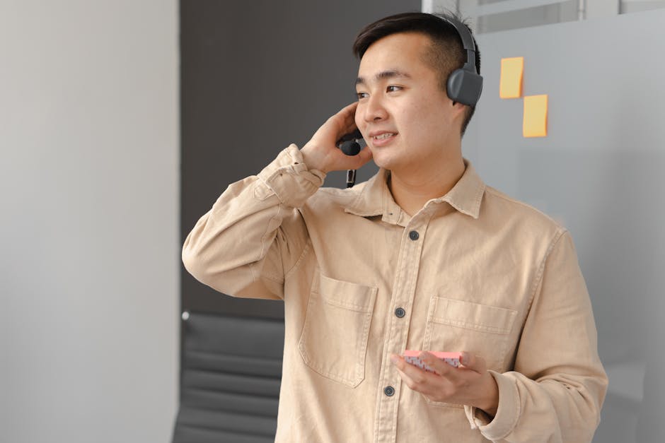 Man in Beige Dress Shirt Wearing Gray Headphones