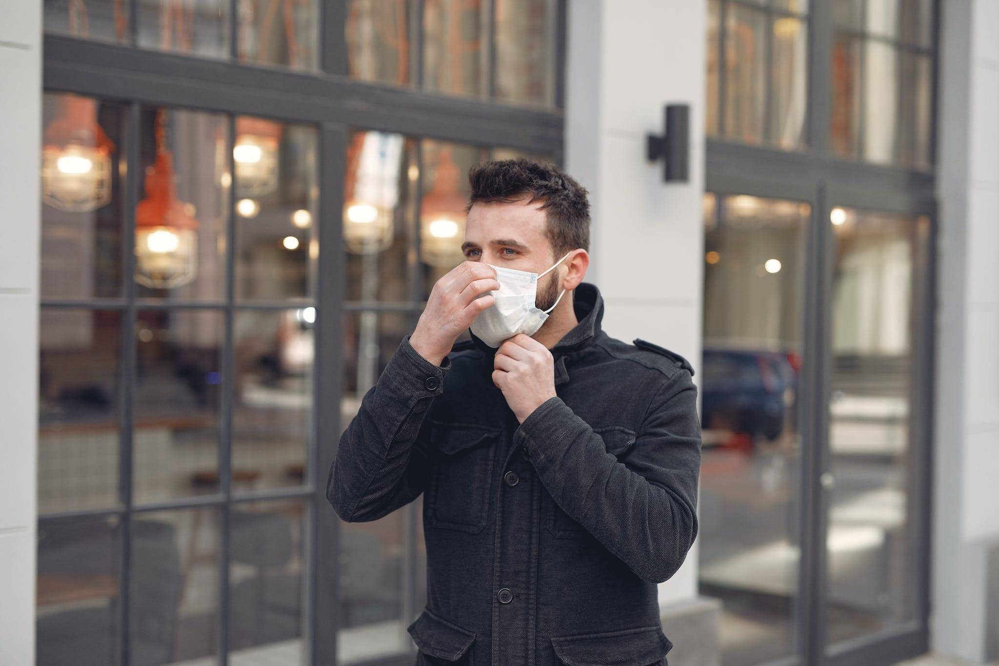 Young man in medical mask on urban street during Coronavirus pandemic