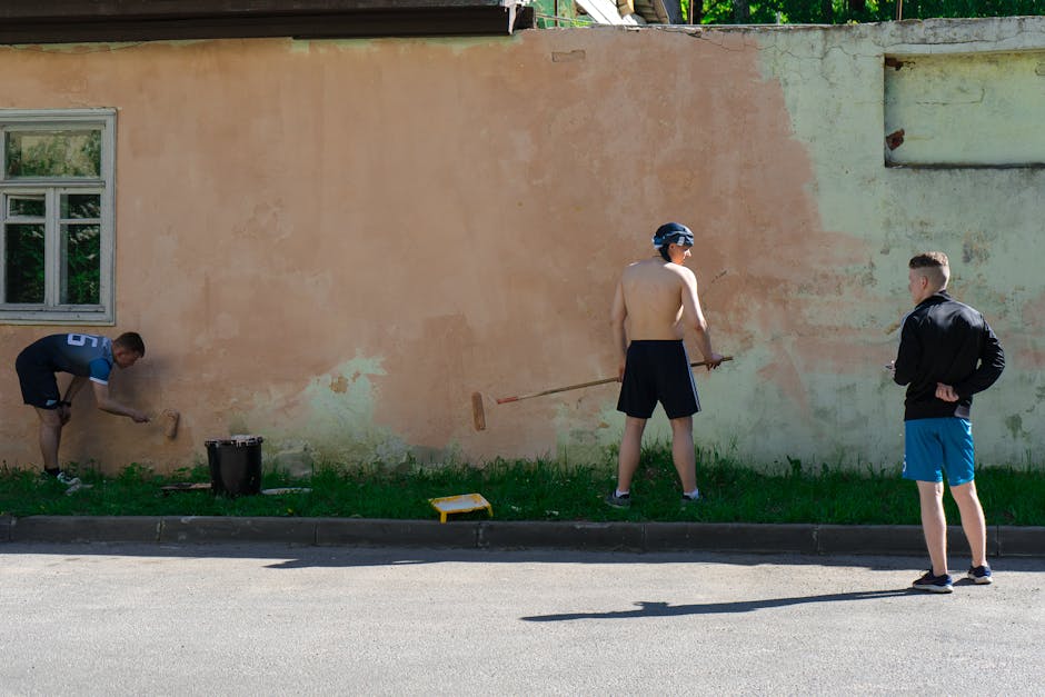 Young Men Painting a House Facade and a Wall