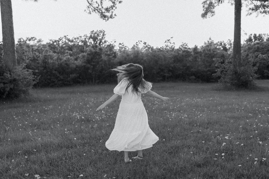 Anonymous girl spinning around on lawn