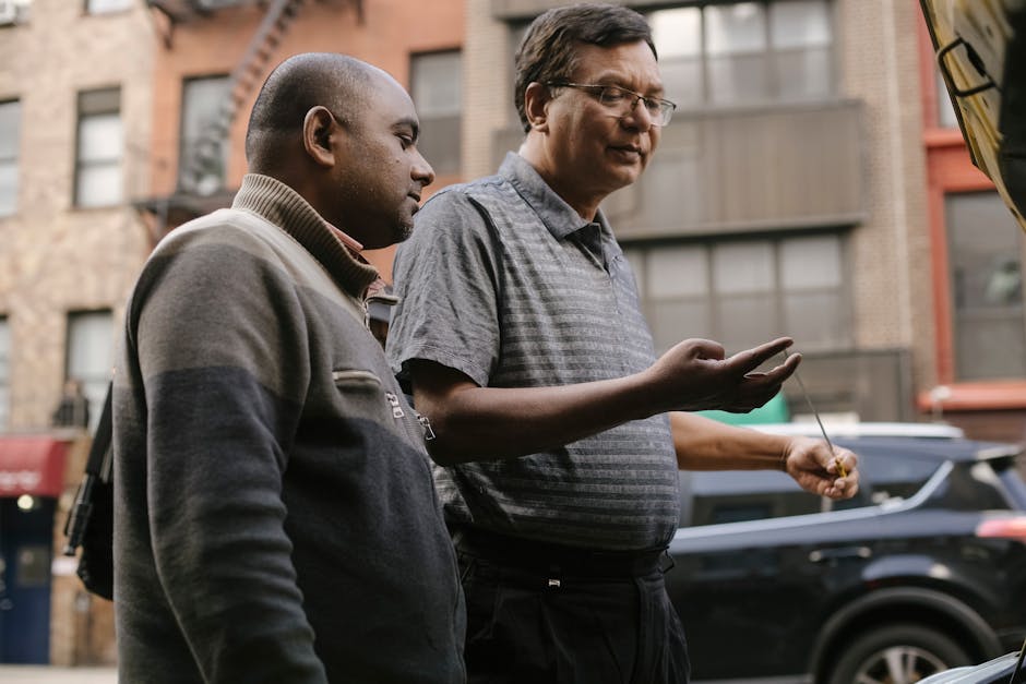 Side view of multiethnic male partners in casual apparel speaking against building in town