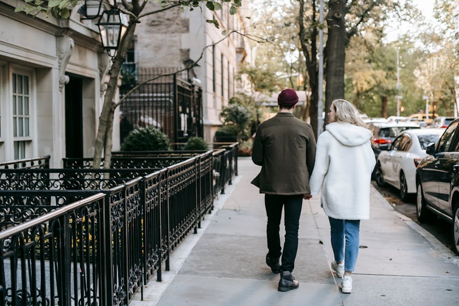 Stylish young couple walking in city residential district