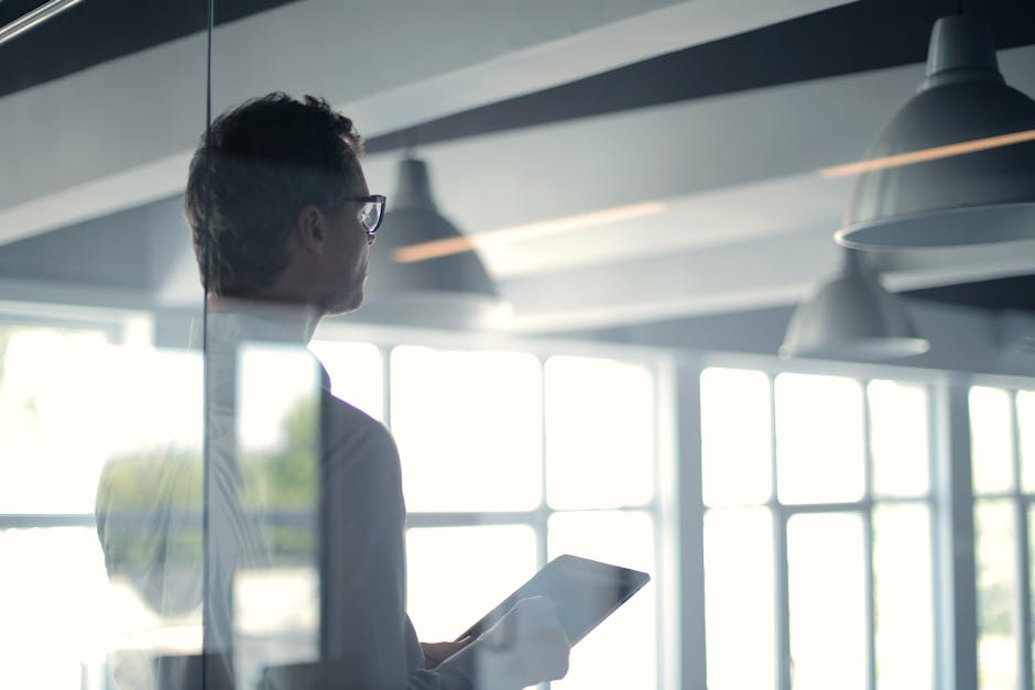 Formal man with tablet giving presentation in office