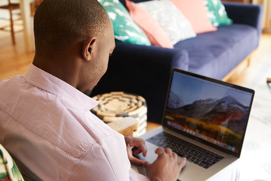 Black man freelancing on laptop in cozy room