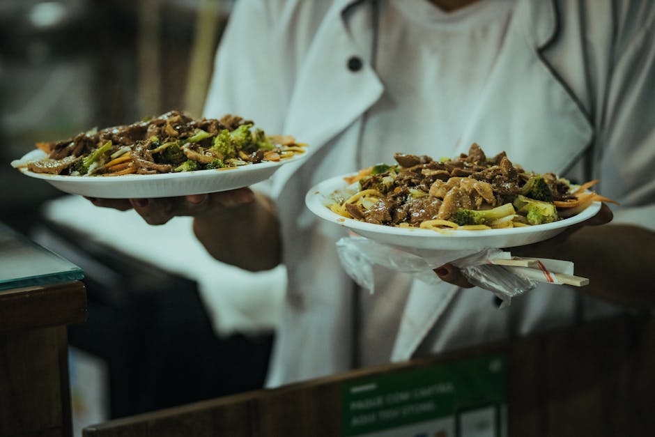 A person holding two plates of food