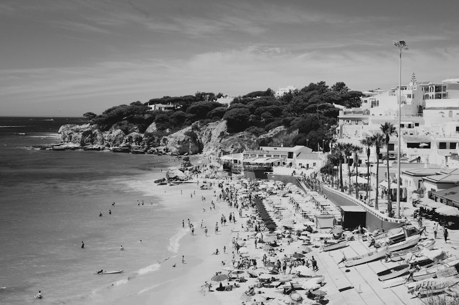 Black and white photo of beach with people and buildings