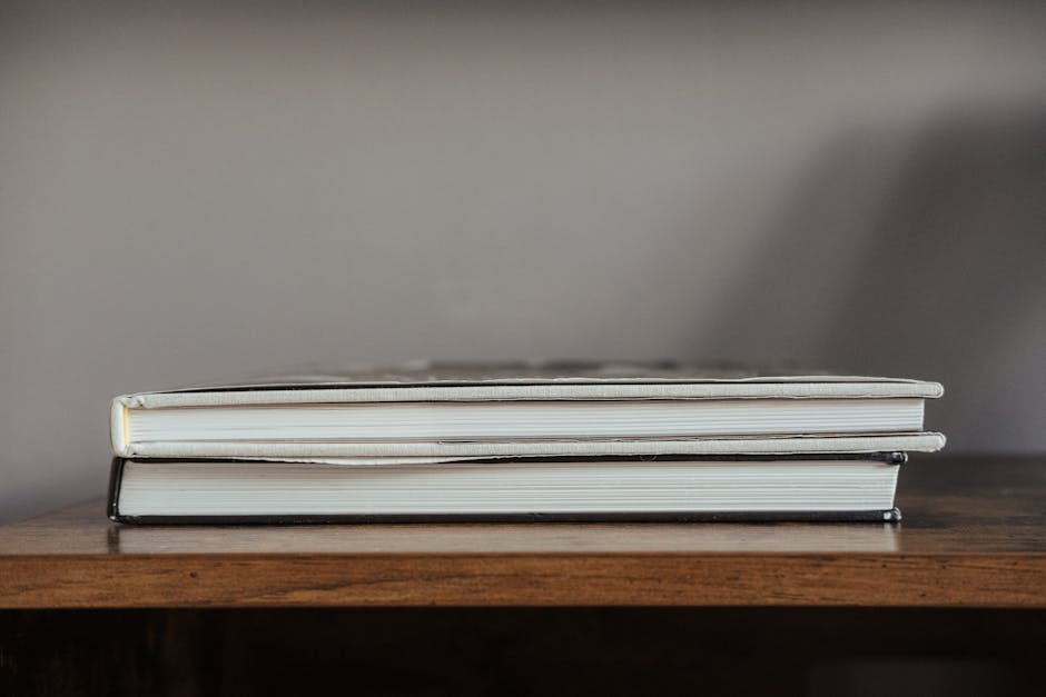 Books with hardcovers stacked on wooden table prepared for exam preparation in flat