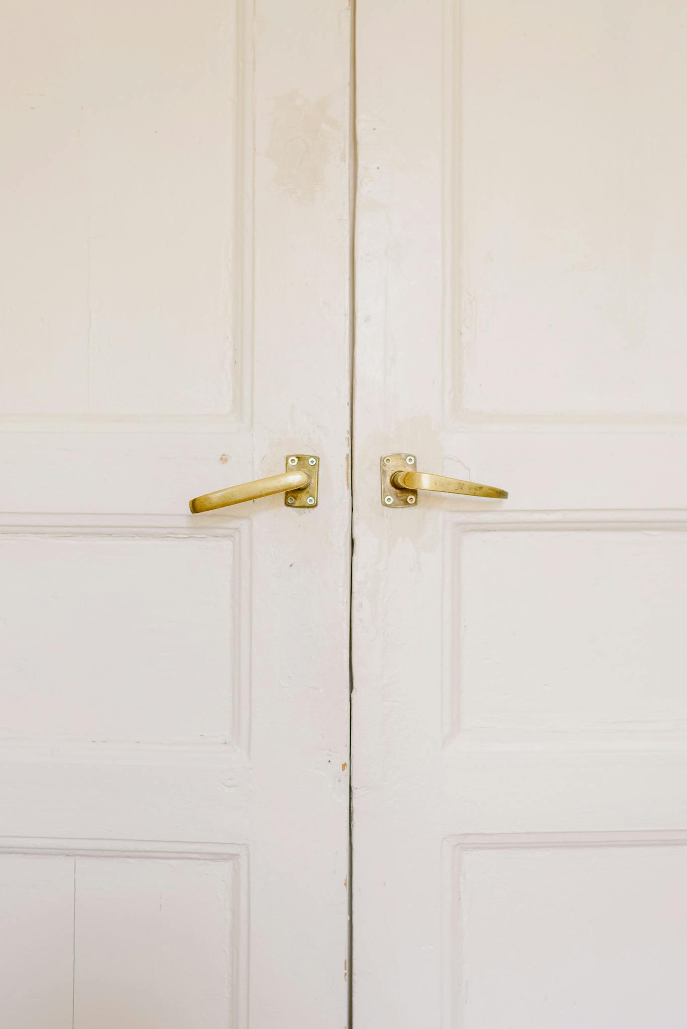 Contemporary wooden building doors with uneven surface and bright metal handles fixed with screws