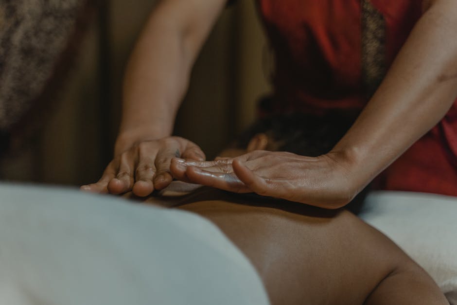 Hands Massaging the Person’s Back