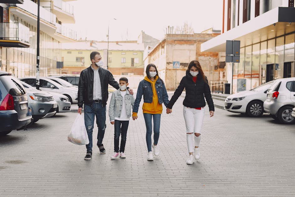 Young family in medical masks walking along parking