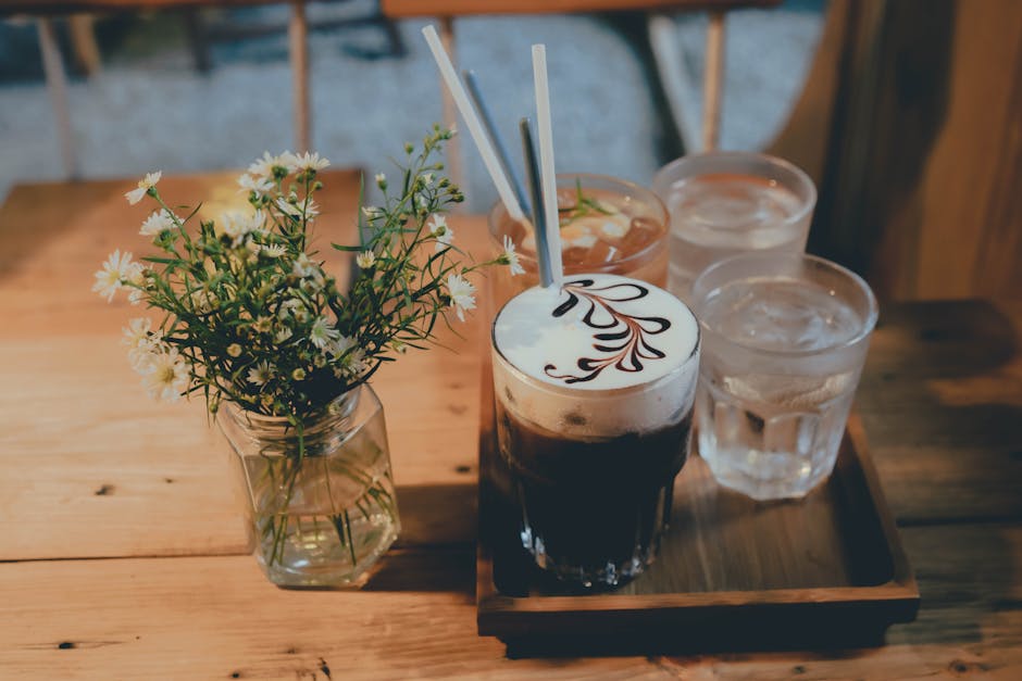 A tray with two drinks and flowers on it