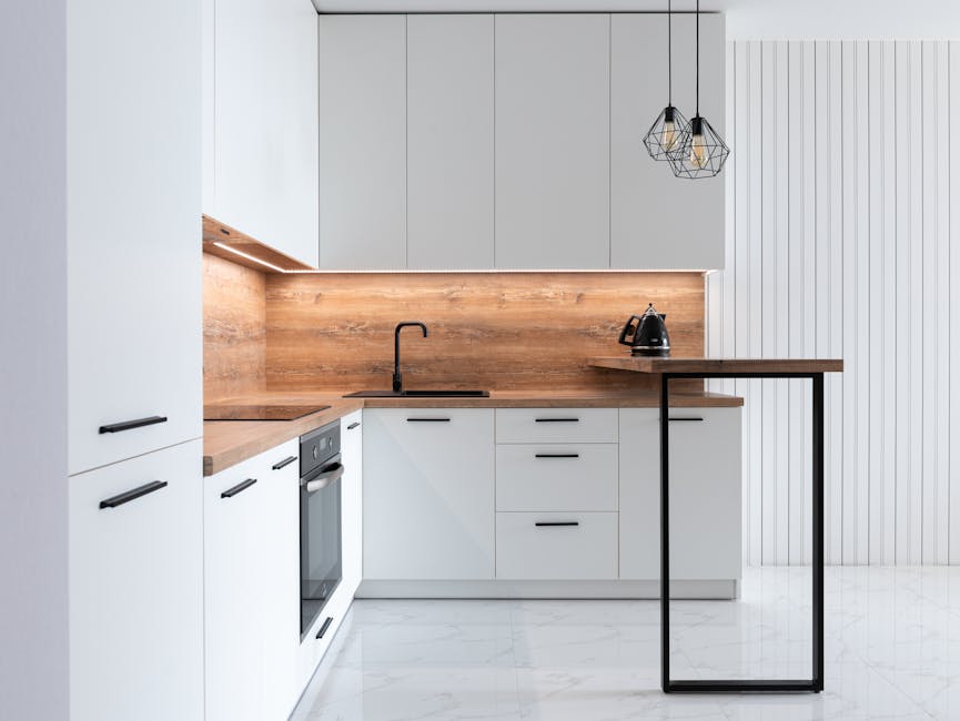 Contemporary interior of modern kitchen with comfortable white furniture and geometrical lamps hanging on ceiling