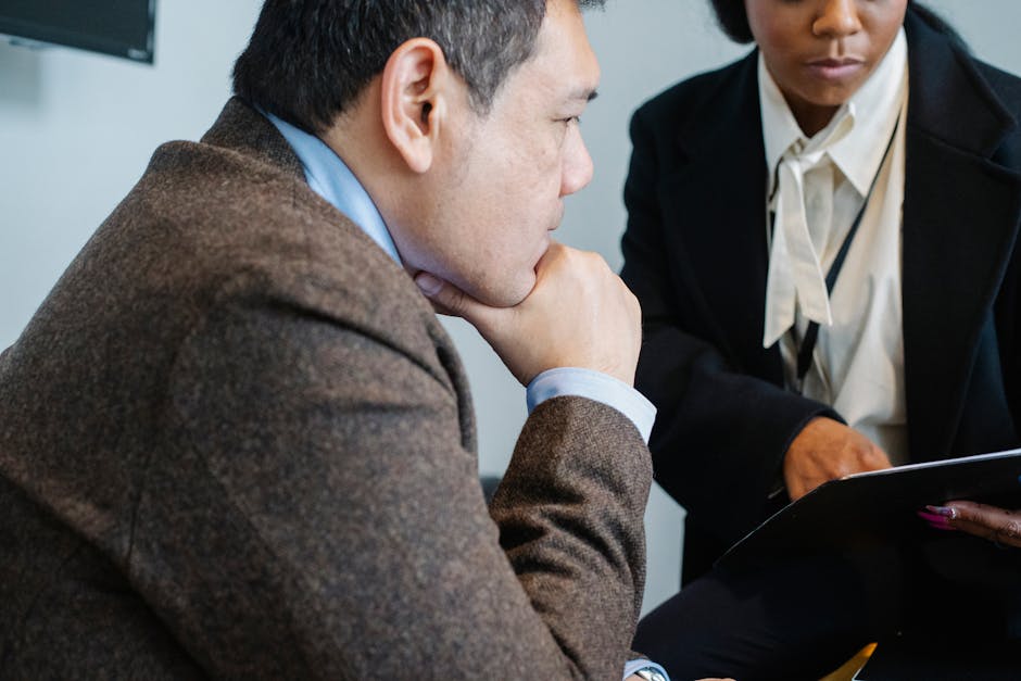 Serious diverse coworkers reading contract in office