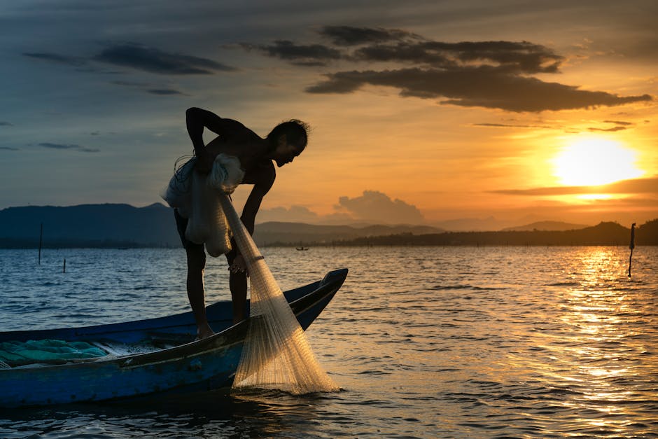 Man on Boat Holding White Mesh Fishing Net