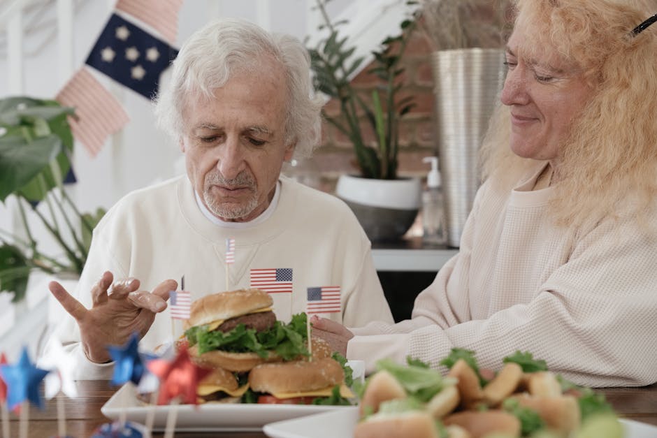 Elderly Couple Eating Burgers while Celebrating 4th of July