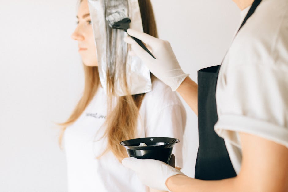 A Hairdresser Coloring a Woman’s Hair