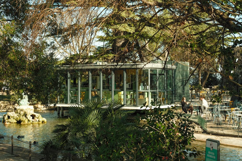 A glass house in the middle of a park