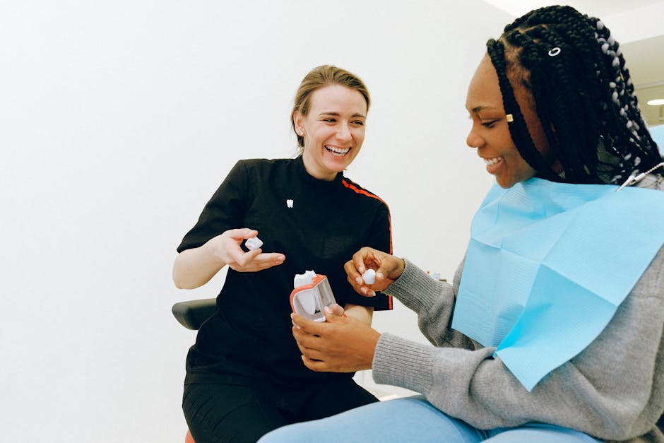 Cheerful young female dentist discussing tooth structure with client