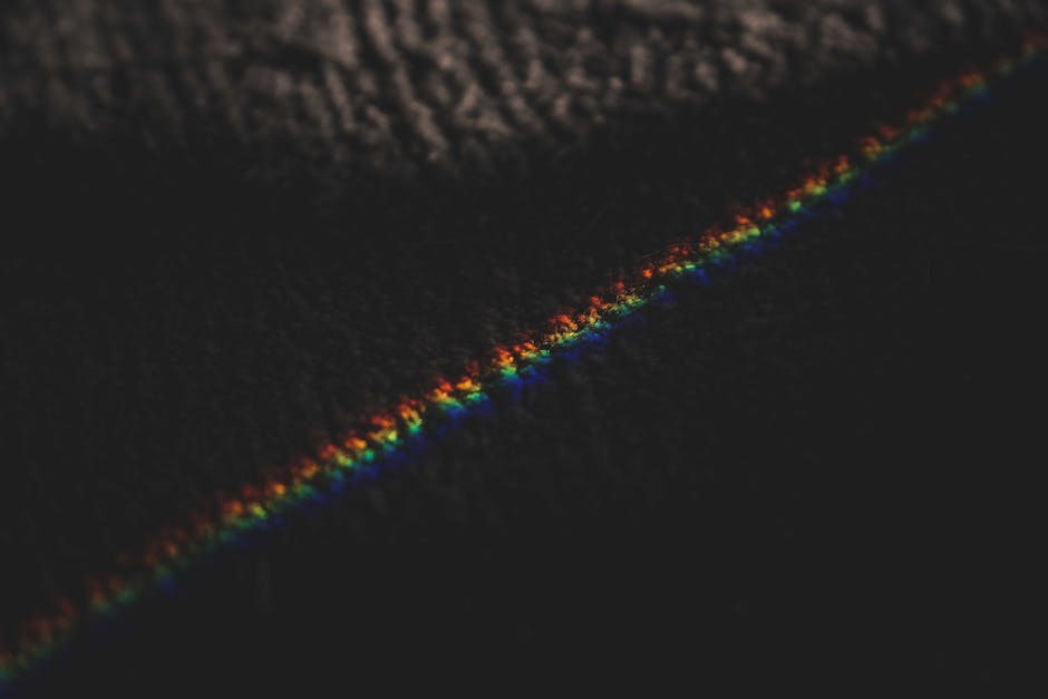 From above of rainbow ray light formed from refraction passing through prism on rug