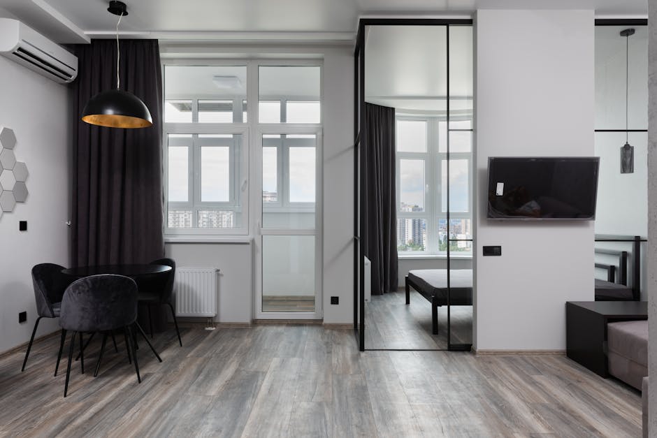 Contemporary room interior with chairs under lamp and air conditioning in light house with glass wall