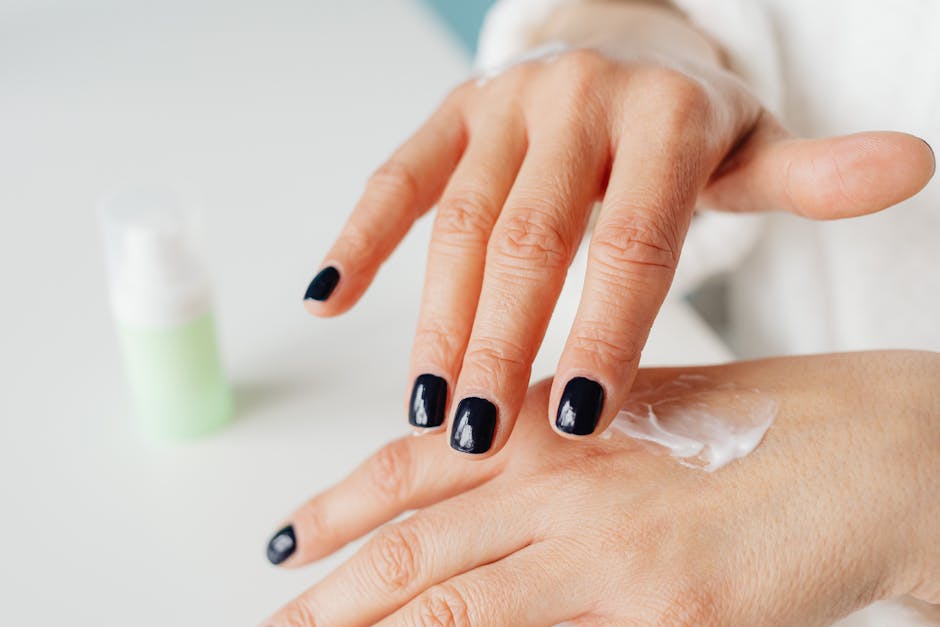 Close-up of Woman Spreading Cream on the Back of Her Hand