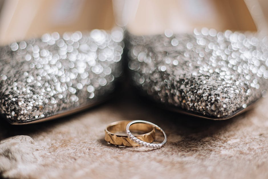 Two wedding rings are placed on top of a pair of shoes