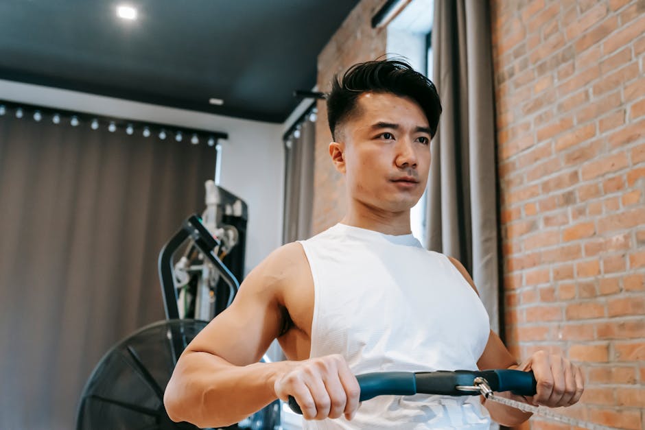 Young Asian man using gym equipment for keeping fit