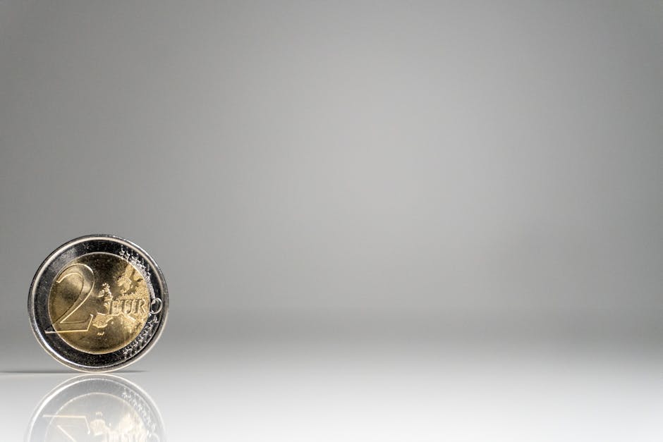A coin on a white surface with a reflection