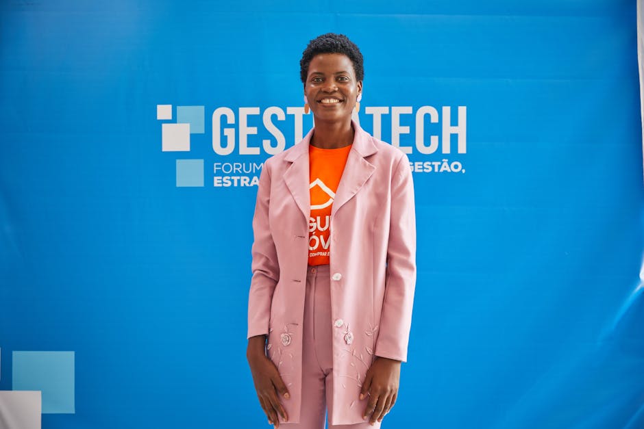 A Woman in Pink Suit Against a Blue Photo Wall