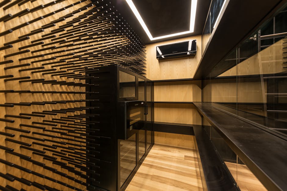 A Luxury Wine Storage Faciltiy, interior with dowels in wall against shelves and air conditioning under shiny lamp in house